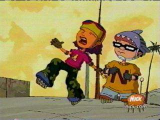 Reggie, wearing rollerblades, throwing a slice of pizza, with Sam standing behind her... they're both in their regular clothes, with adequate safety gear, and it looks a bit as if Reggie is whining